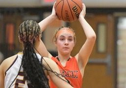 Woman basketball player holding ball above head